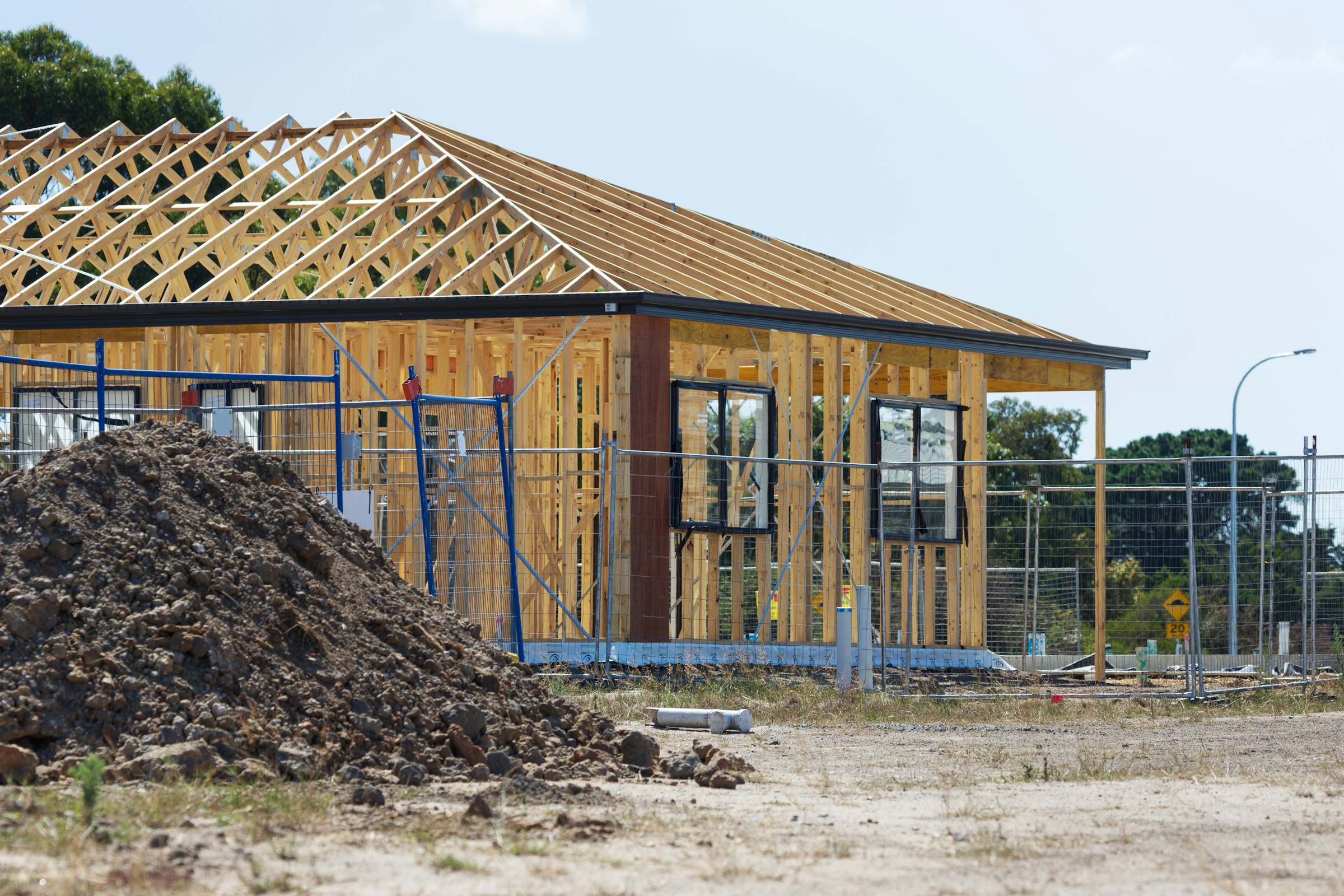 Modern home under construction with timber framing and roof trusses